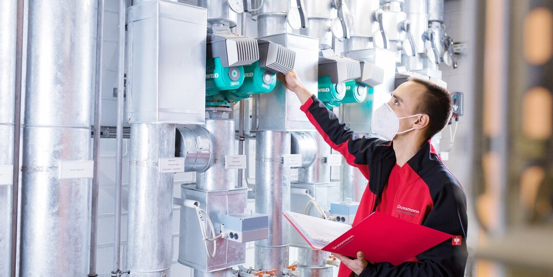 Techniker der Gebäudetechnik prüft Pumpenanlage