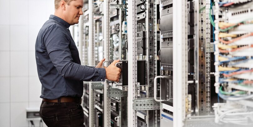 Sicherheitsfachkraft untersucht Netzwerktechnik im Bereich Sicherheitsdienst, Sicherheitstechnik