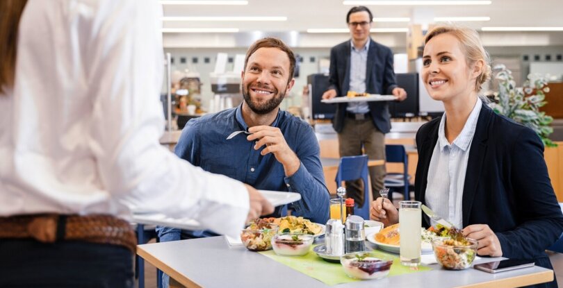 Mann und Frauen essen Mittag in Kantine