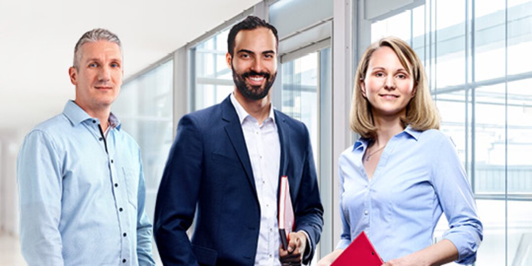 Gruppenbild von drei lächelnden Dussmann-Mitarbeitenden aus dem kaufmännischen Bereich. 
